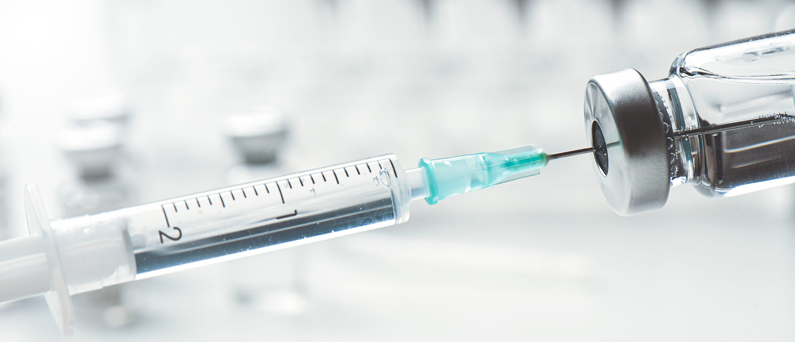 Vaccine bottle and syringe closeup Vaccine bottle and syringe. Influenza, flu, corona virus vaccine concept