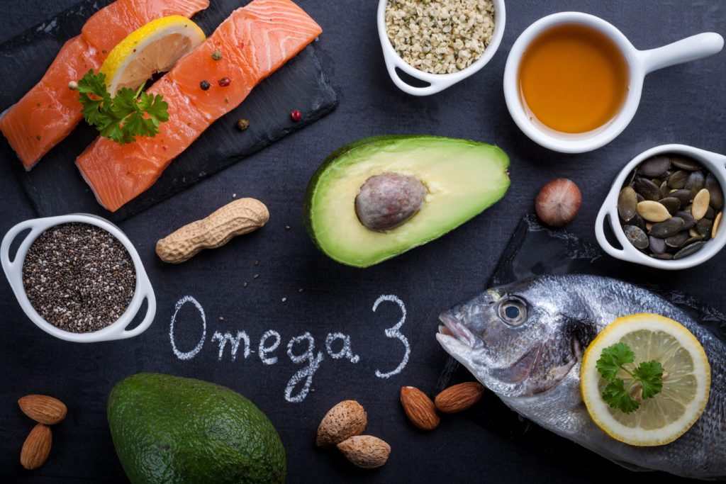 Black slate table with product rich in omega 3 and vitamin D. Written word omega 3 by white chalk. Black slate table with product rich in omega 3 and vitamin D. Written word omega 3 by white chalk.